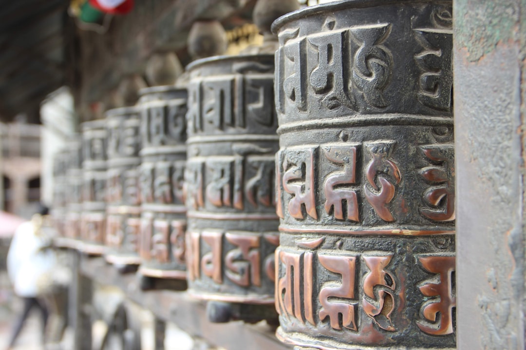 A close-up of ancient Tibetan prayer wheels with detailed inscriptions, symbolizing spiritual contemplation